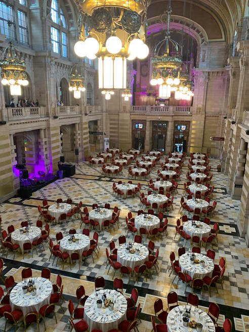 A grand museum with lots of tables set for dinner